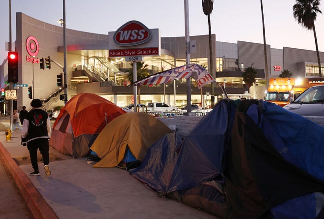 A person walks past a homeless encampment near a Target store on Sept. 28, 2023 in Los Angeles. State and local lawmakers, both Republicans and Democrats, are seeking to overturn lower court decisions which currently block their power to clear encampments with unhoused people. Dozens of leaders, many from Western states including California, have turned to the Supreme Court to overturn the rulings. Skid Row is home to thousands of people who either live on the streets or in shelters.