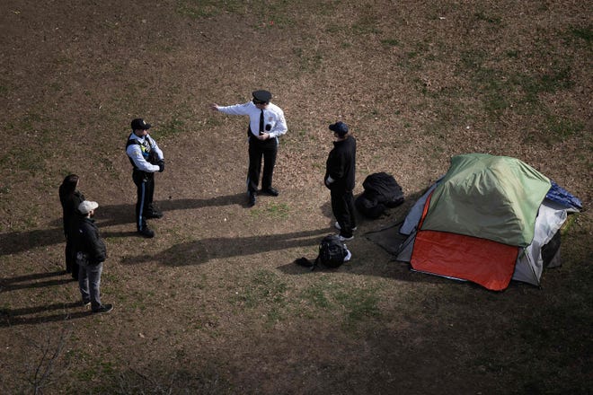 Park Police talk to a man who refused to leave after members of the US National Park Service cleared a homeless encampment from McPherson Square, two blocks from the White House in Washington, DC, on Feb. 15, 2023.