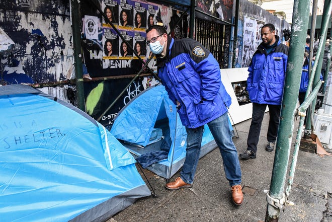 Members of the New York City police work with the Department of Sanitation to clear a homeless encampment near Tompkins Square Park on April 6, 2022 in the Manhattan borough in New York City.