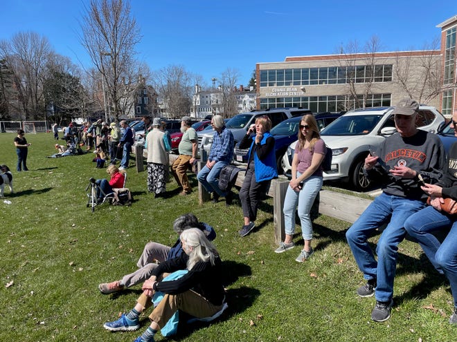 A crowd begins to gather to view the eclipse outside Portsmouth Public Library Monday, April 8, 2024.