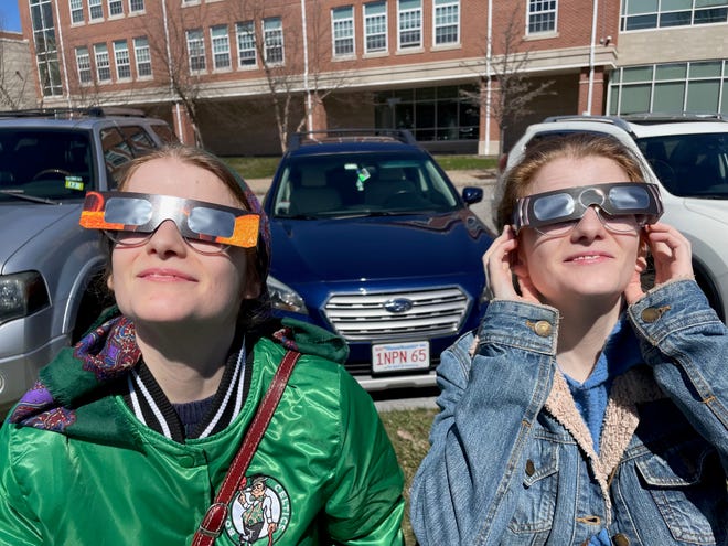 Sisters Kathleen and Sarah Brewster get ready to view the eclipse outside Portsmouth Public Library Monday, April 8, 2024.