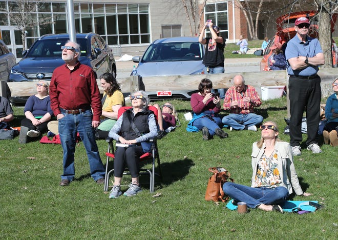 A crowd gathered to view the eclipse outside Portsmouth Public Library Monday, April 8, 2024.