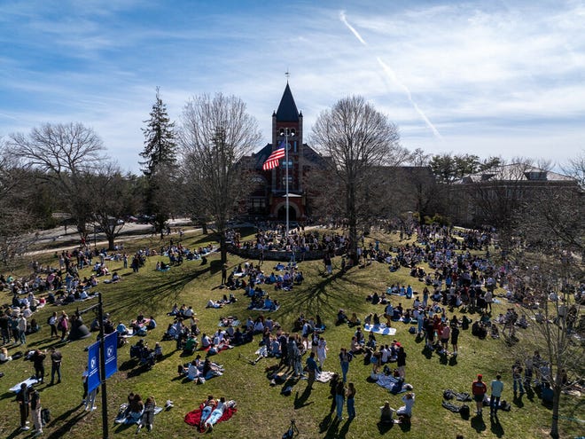 Students gather for an eclipse viewing event at the University of New Hampshire on the Thompson Hall lawn Monday, April 8, 2024.
