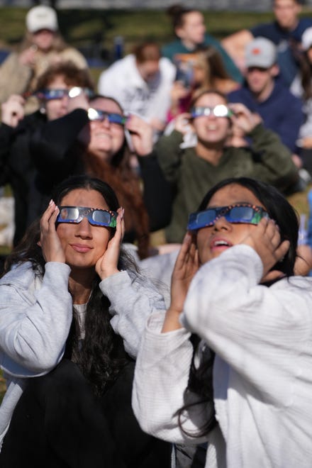 Students gather for an eclipse viewing event at the University of New Hampshire on the Thompson Hall lawn Monday, April 8, 2024.